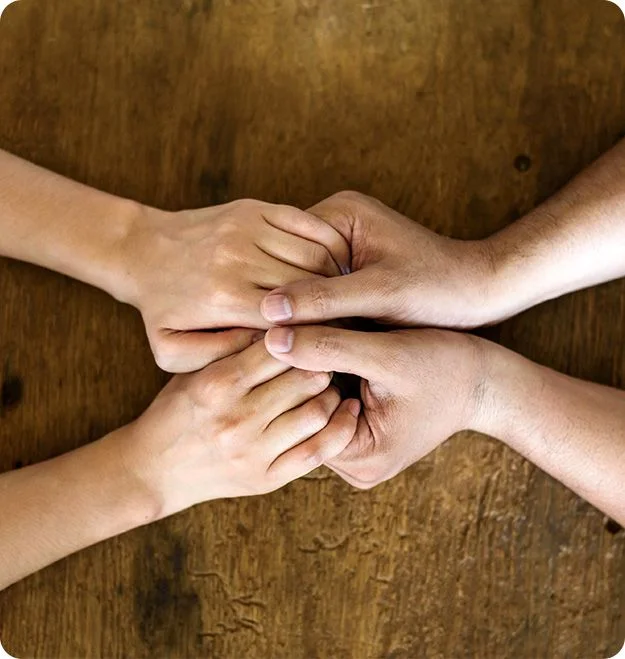 Couple holding hands over a wooden table