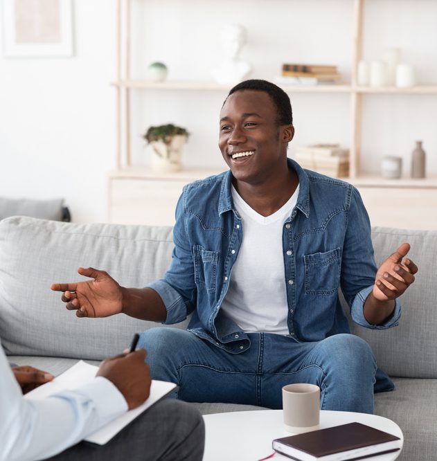 Successful therapy with a cheerful black man talking to psychologist